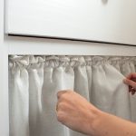 image of hands arranging fabric on pantry cabinet skirt