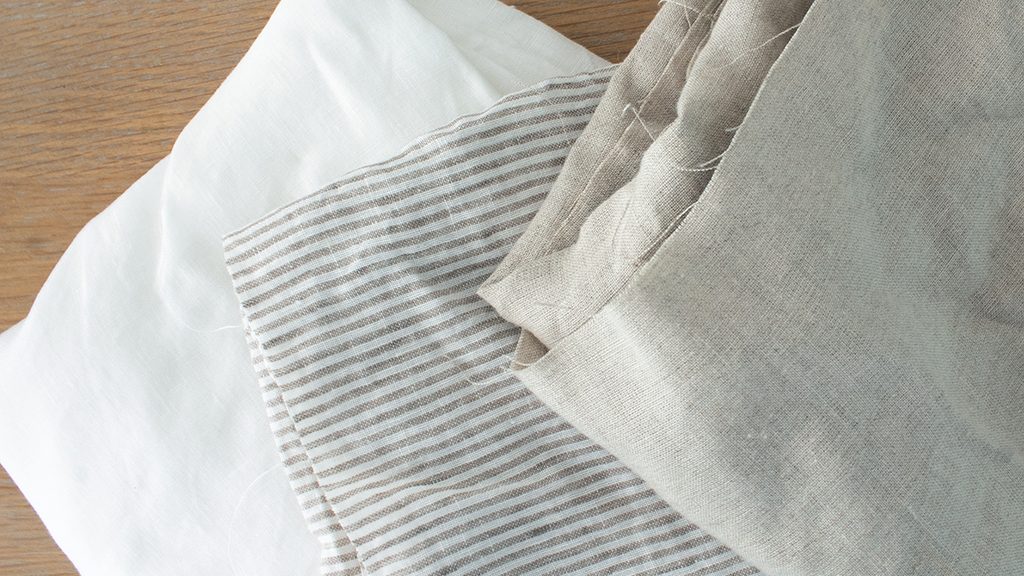 image of white linen, ticking stripe linen, and beige linen. fabric options for cabinet curtains