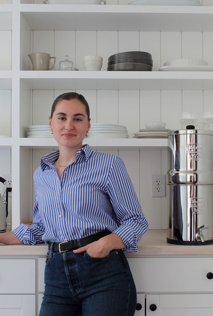 Ruby of Thyme On Our Hands standing against pantry butcher block counter. White shiplap and DIY pantry shelving behind her