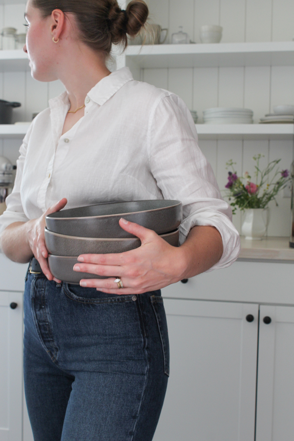 Ruby of Thyme On Our Hands holding stack of grey plates