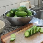 Sliced garden fresh pickling cucumbers on wooden chopping board