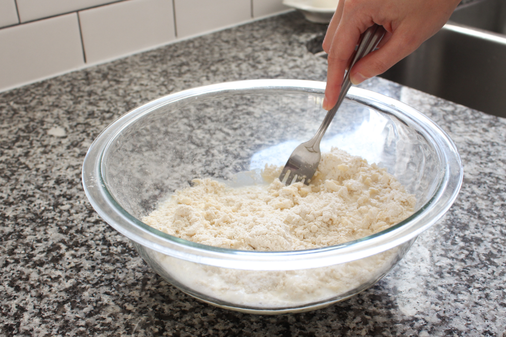 Stirring cold milk into homemade biscuits dough