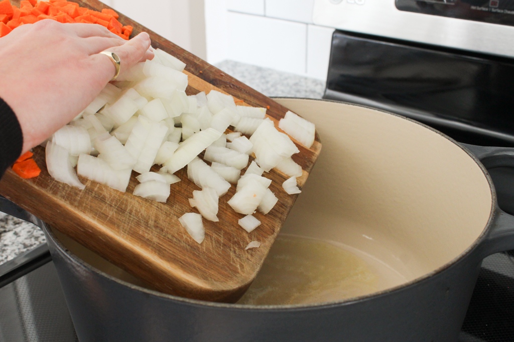 Adding diced onions and carrots to One Pot Pasta with Sausage and Kale