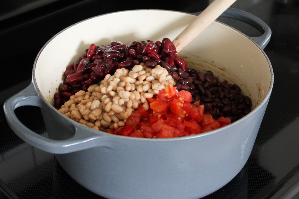 adding in the beans and tomato in chili