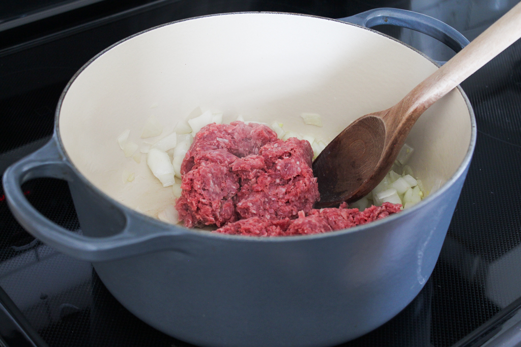browning ground beef in a grey dutch oven