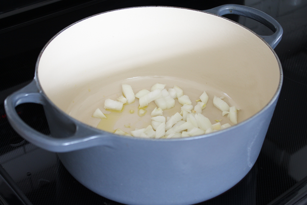 sautéing onions in a grey dutch oven