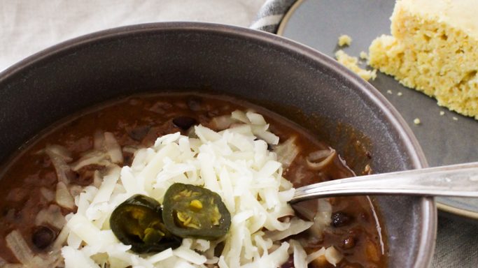 Easy 30 minute meal recipe for chipotle chili and homemade cornbread from-scratch in the background
