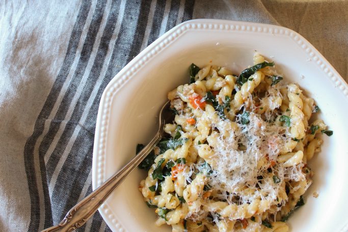 Overhead shot of One Pot Pasta recipe with Sausage and Kale in dutch oven and bowl