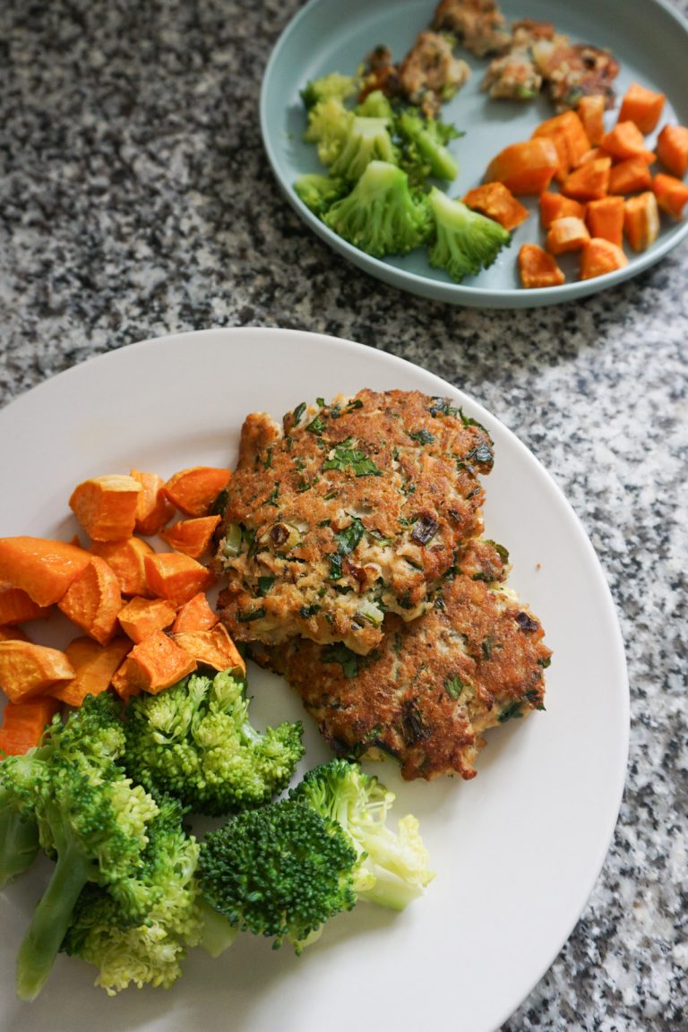 Two plates with salmon cakes, sweet potatoes, and steamed broccoli for an easy lunch for busy moms and toddlers