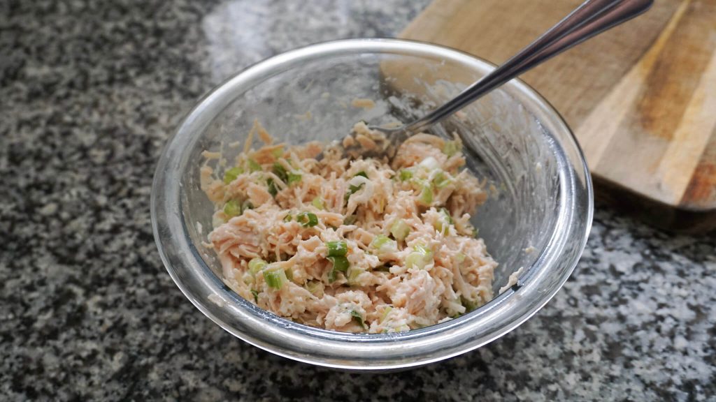 Easy canned chicken salad in a mixing bowl with mayo added