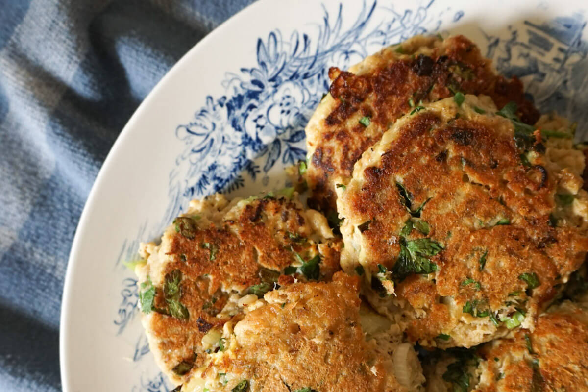 Close up shot of plate of salmon patties made with canned salmon lemon and parsley