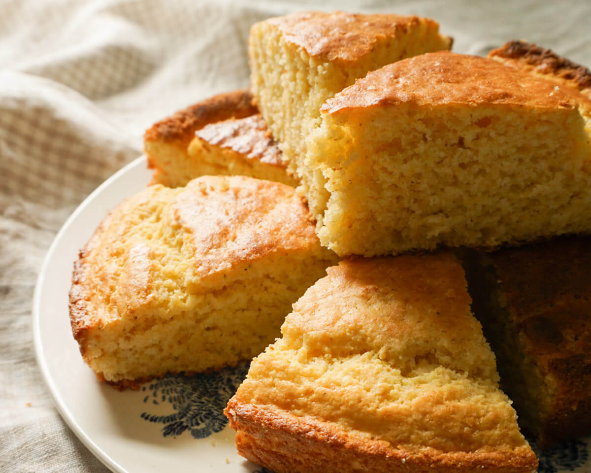 Slices of homemade cornbread stacked on a plate
