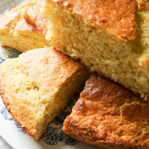 Slices of homemade cornbread stacked on a plate