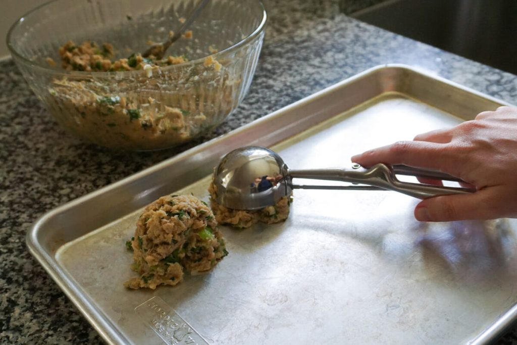 Scooping gluten free salmon patties mixture into balls