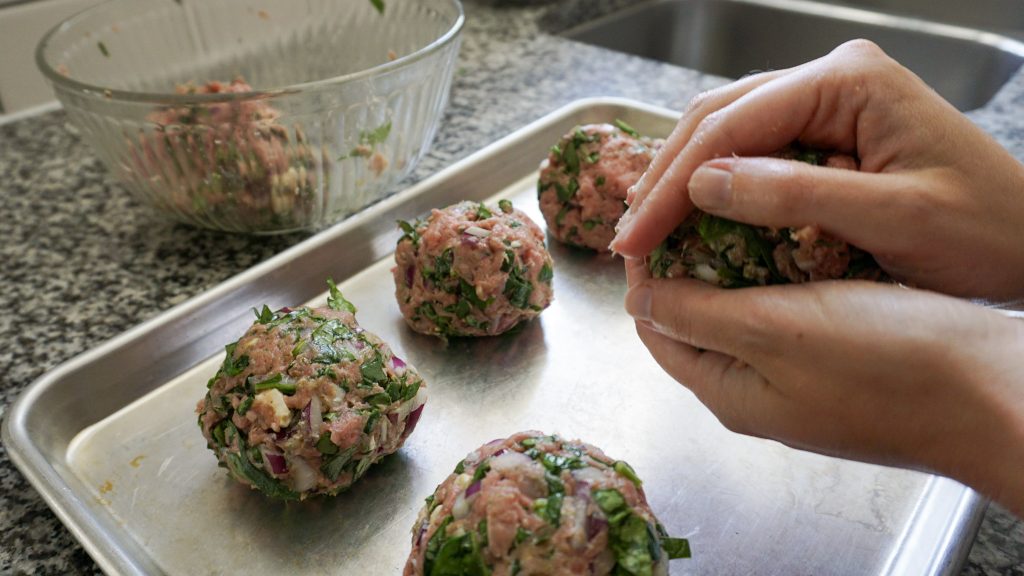 Shaping homemade Greek turkey burger mix into patties
