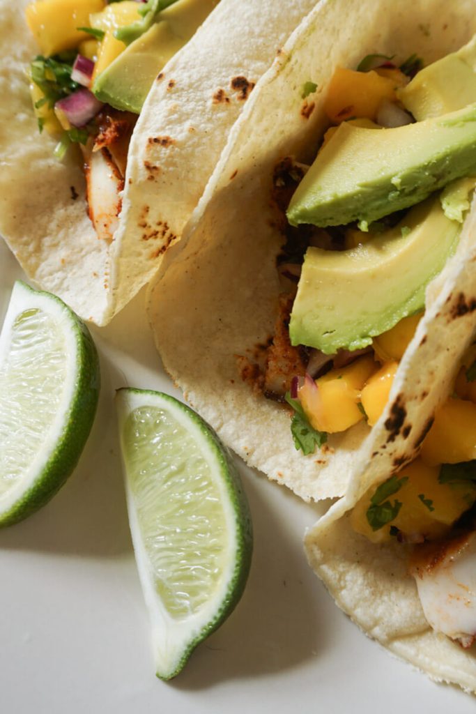 Zoomed in shot of baked fish tacos with mango salsa