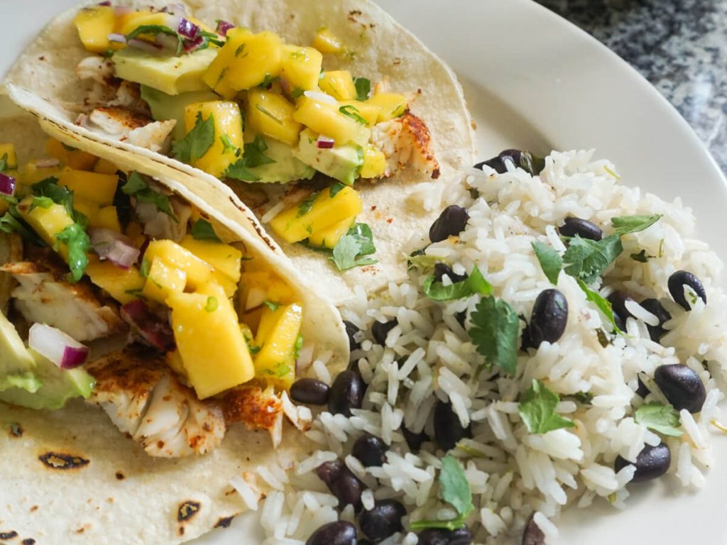 Plate with easy baked fish tacos and cilantro lime rice and beans