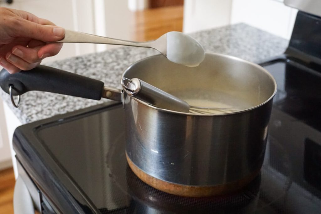 Cooking homemade vanilla pudding until it is thick