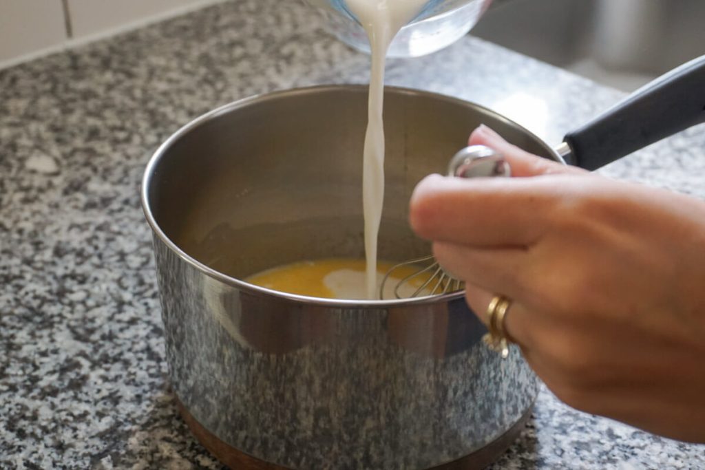 Pouring milk into homemade vanilla pudding