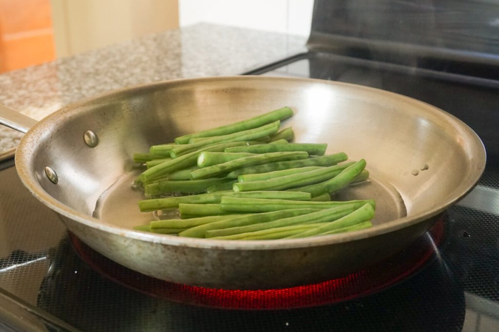 Sautéing green beans for grilled steak with chimichurri sauce dinner