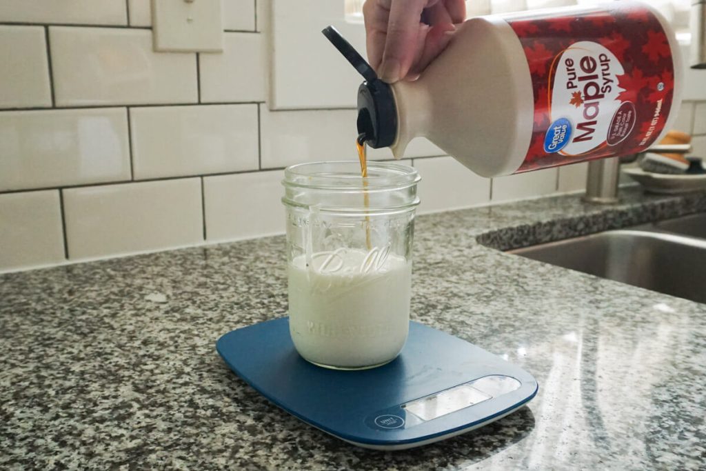 pouring maple syrup in chia pudding base