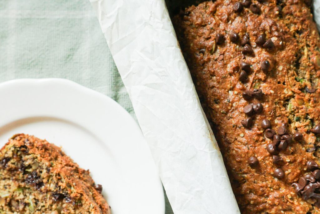breakfast zucchini bread in pan with slice next to it