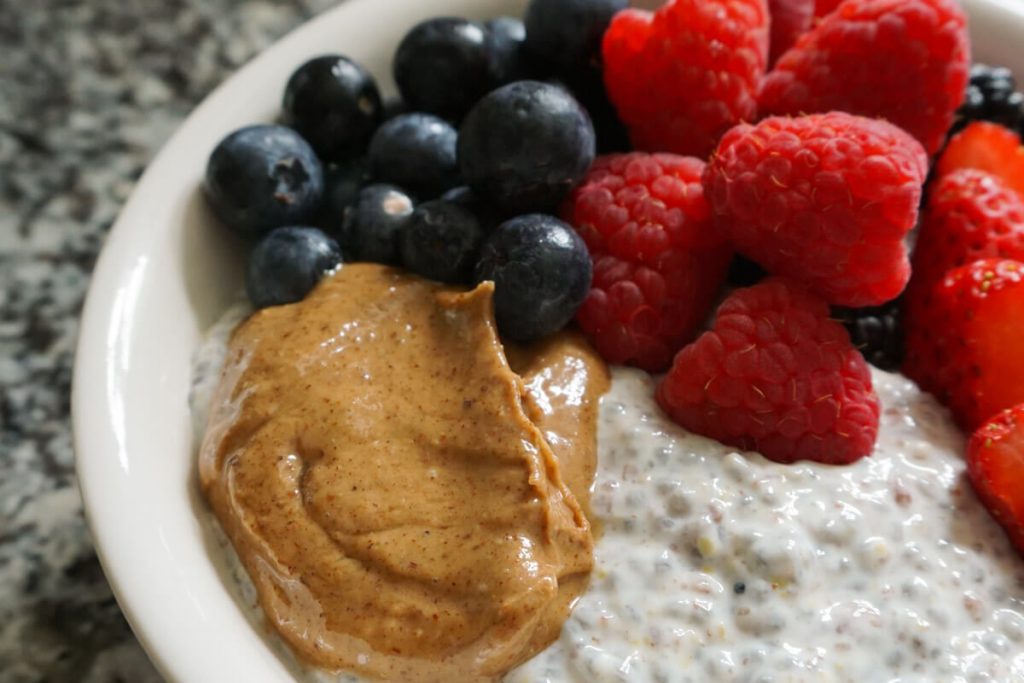 bowl of high protein chia seed pudding with berries and almond butter on top
