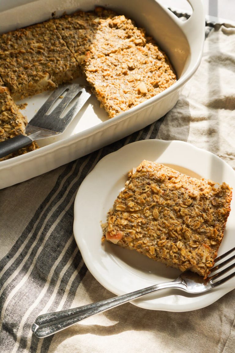 slice of apple pie baked oatmeal next to prepared 9x13 dish of fall make ahead breakfast idea