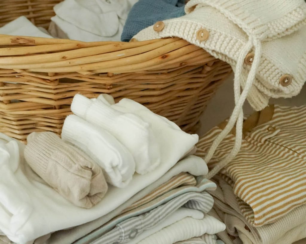 `qaBasket of baby clothes and other intentional newborn essentials