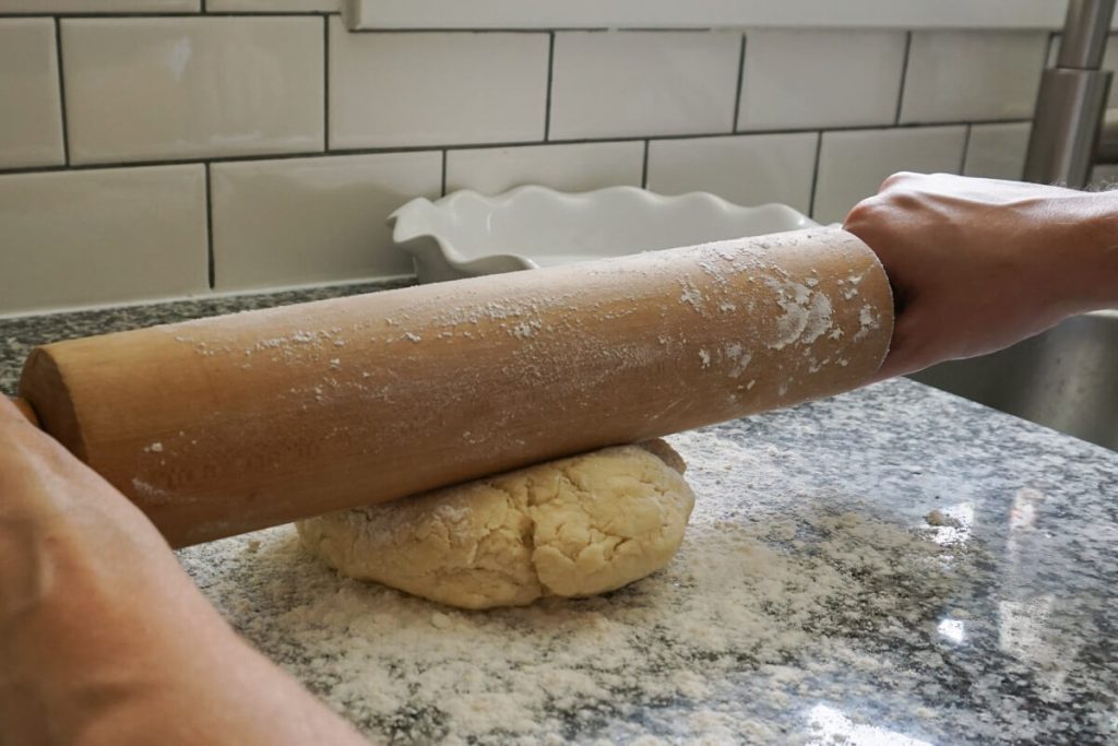Rolling out homemade pastry for quiche crust