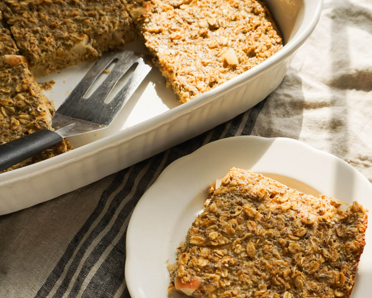 slice of apple pie baked oatmeal next to baked make-ahead fall breakfast